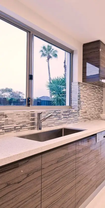 The kitchenette is placed under a window as part of the interior of a container home.